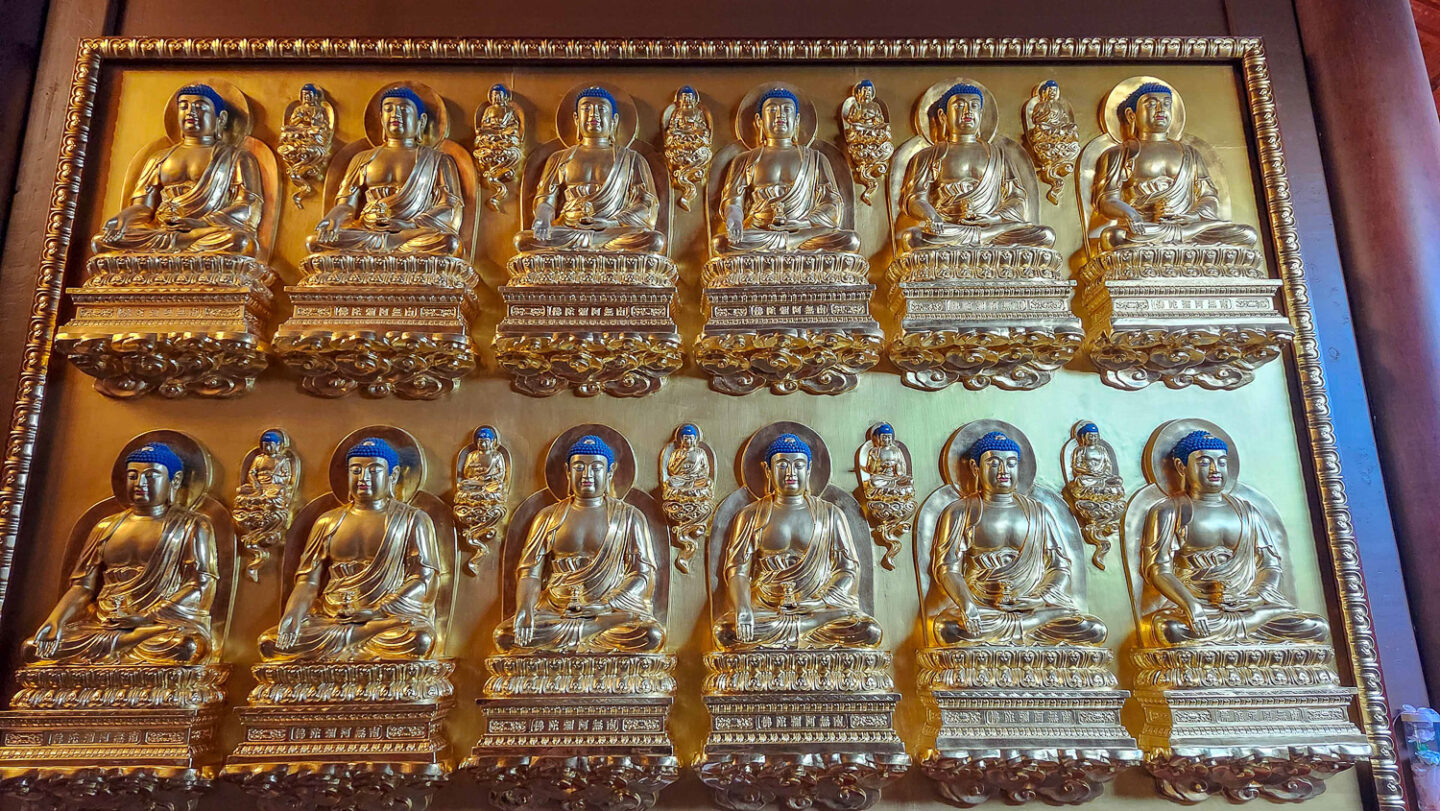 Detailed wall of small Buddhas on the third floor of the main temple