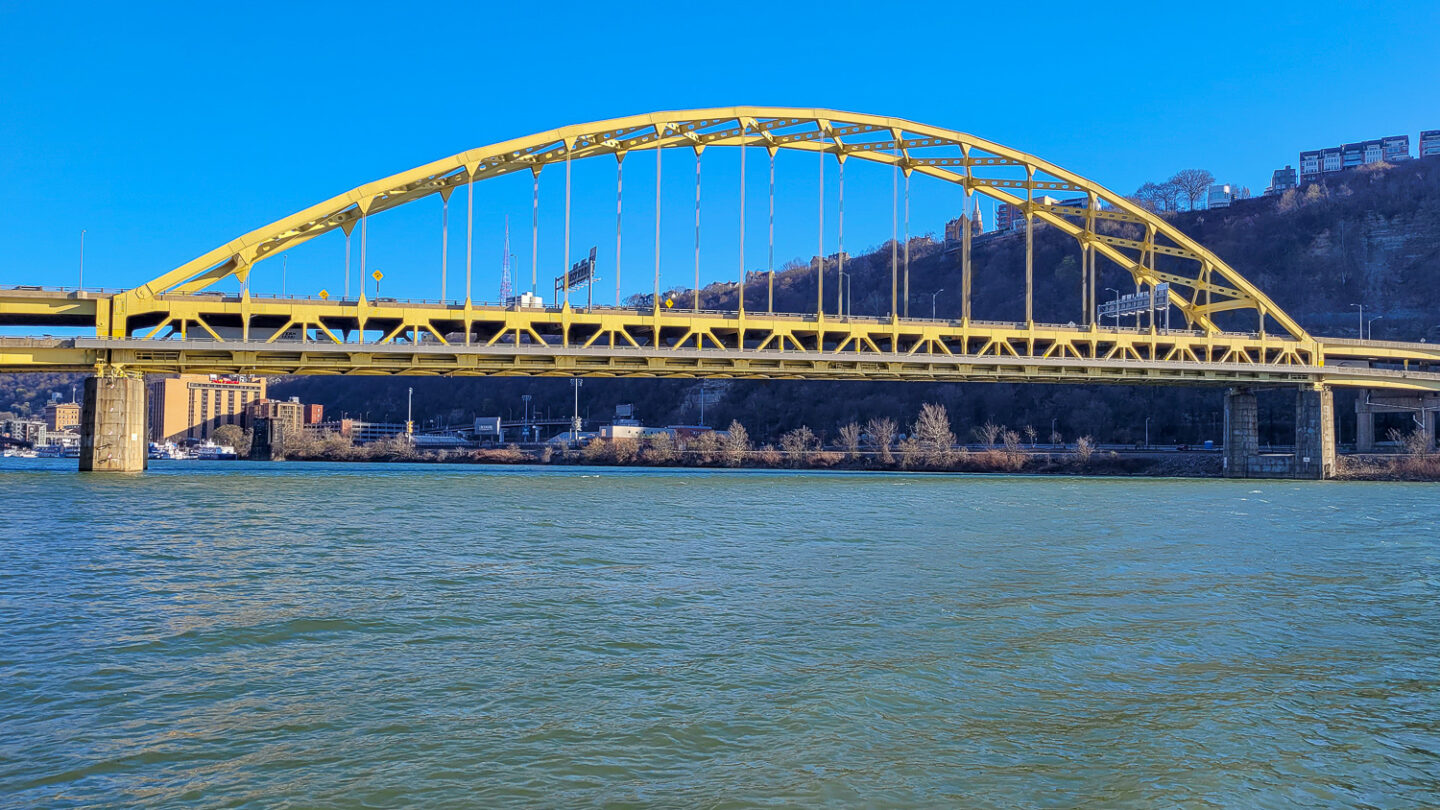 Side view of yellow Pittsburgh bridge which is one of the things to do during a weekend in Pittsburgh